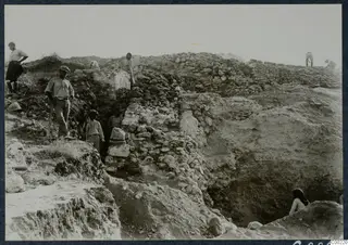 Workers excavating the substructure walls of the east eisodos of the theatre at Soli, among rubble-built stone walls.