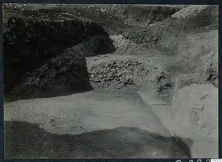 Excavation trench at Soli with rubble stone walling and a long stone edge running across the right foreground