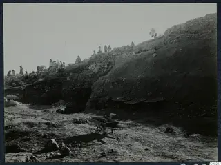 Excavation of the theatre at Soli, with people working along the upper slope and wheelbarrows in the foreground.