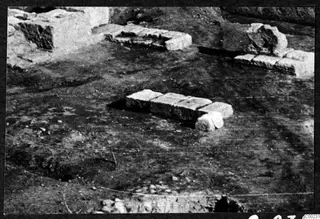 Excavated ground at Soli theatre with cut stone blocks in a low row and worked stones beside a wall