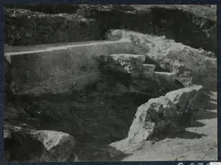 Excavated stone steps beside a large dressed block at the theatre at Soli