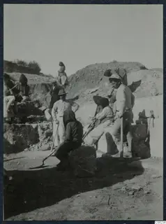 Workers with spades and picks among large stone blocks at the excavation of the theatre at Soli