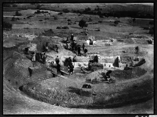 Excavation of the theatre at Soli, with workers clearing the proskenion and wheelbarrows running on planks