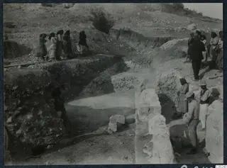 Excavation at the theatre at Soli, with a row of women on a trench edge and men beside cut stone walls