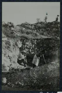 Excavation trench at the theatre at Soli, with two workers beside a stone wall and a third person on the spoil heap