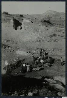 Excavation of the theatre at Soli, with workers digging and two wheelbarrows in use on a dry hillside