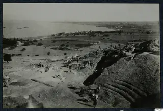 Excavation of the theatre at Soli, with workers, a tent and the sea beyond