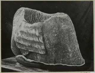 Fragment of a marble sculpture, a kore, from Galini, with carved parallel ridges