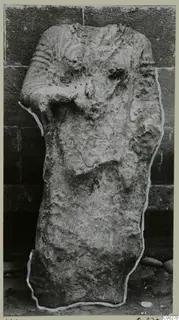 Limestone sculpture from Vouni, a worn upright figure with a weathered face and a bent arm