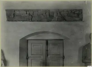 Marble relief of horsemen fighting, from Soli, fixed high on a wall above an arched double door