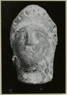 Terracotta head from Soli, shown frontally against a dark background.