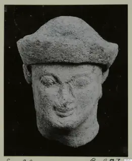 Head figurine with a flat-topped cap and smiling face, from the Soli finds, photographed on a black background