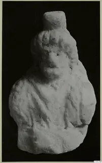 Marble sculpture of a head and upper body with wavy hair and draped shoulders, against a dark background