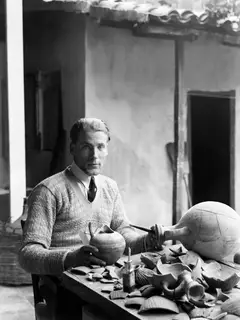 Alfred Westholm conserving pots at a table covered with sherds, in a courtyard in Nicosia