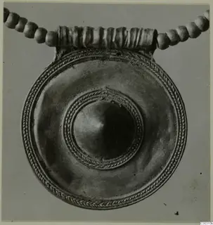 Round disc pendant with a domed centre and rope-twist border, hung from a ribbed loop on a beaded cord