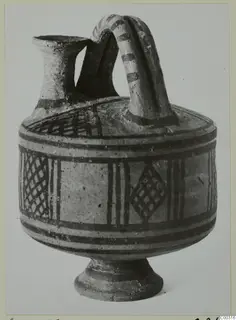 Pottery Bichrome I askos from the Lapithos Kastros tombs, with a spout, strap handle and painted bands and lattice panels.