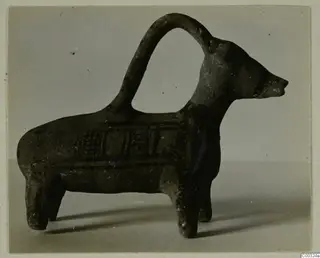 Pottery vessel shaped as a four-legged animal with an arched strap handle over its back, from Lapithos.