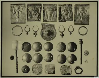 Metal jewellery, embossed plaques and a pale stone object from Lapithos Tomb 403, laid out in rows for photographing