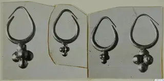 Four gold earrings, each a teardrop-shaped loop with a cluster of round beads hanging from its base, shown in photographs.