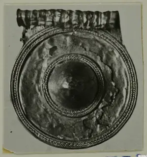 Gold pendant, probably from Lapithos tomb 403, seen face on with concentric twisted-wire rings and a ribbed band at the top