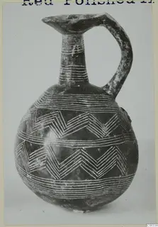 Red Polished II jug from Lapithos with white-filled incised zigzag and horizontal bands on a dark body
