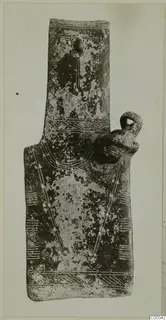 Flat idol-shaped object with incised chevron and band patterns and a loop on its right edge