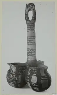 Coupled pottery vessel from Lapithos with a tall loop handle and dark wavy painted bands