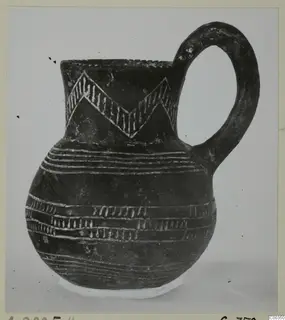 Black polished jug with a loop handle and white-incised zigzag and horizontal band decoration