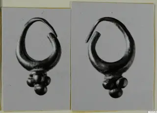 Two photographs of a gold earring with a looped wire and a cluster of small round beads, from Lapithos Tomb 417