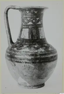 Bichrome wheel-made jug with a strap handle and painted bands and scroll motifs on the neck and shoulder
