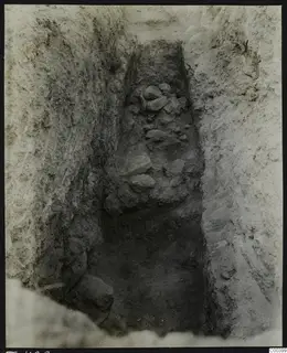 Excavation cutting at Tomb 428 at Lapithos, with stones lying in the narrow trench