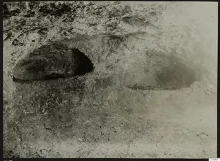 Tomb 309 at Lapithos: rock-cut tomb chamber during excavation, with bone remains on the floor at the right