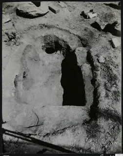 Tomb 307 at Lapithos, Vrysi tou Barba, during excavation, showing a dark rectangular tomb opening cut into the soil