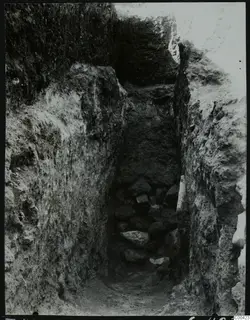 Narrow excavated cutting at Lapithos Kastros, Tomb 420, with a heap of stones at its base