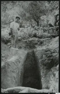 Tomb 410 at Lapithos during excavation: a man with a bucket beside the cut leading to the tomb chamber entrance