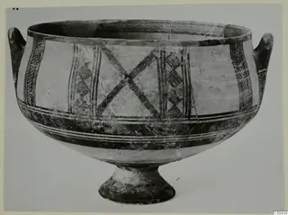 Pottery White Painted I bowl with two handles and a pedestal foot, decorated with crossed bands and lattice panels.