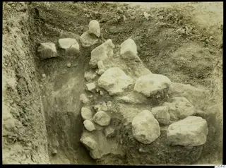 Excavation trench at Plakes, Lapithos, with large limestone blocks and stones exposed in the soil