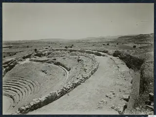 The theatre at Soli, with curved rows of stone steps and a stone retaining wall above a cleared path