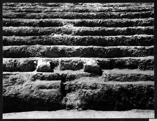 Stepped excavated section at Soli theatre with two pale stone blocks set into the tiers