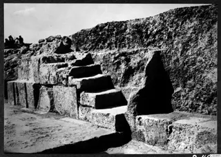 Stone steps of the theatre at Soli, with a few people on the bank at the top left