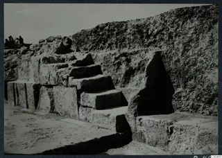 Stone steps set into a wall of large blocks at the theatre at Soli, with a few people at the top left.