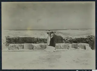 Excavated stone walls at the theatre at Soli, with a narrow central opening framed by a wooden beam