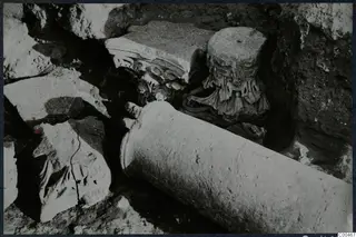 Monasteraki at Soli: a column drum and carved capitals lying among stones in an excavation trench