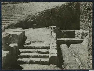 Excavated stone steps at the theatre at Soli, with a cut channel and walls beside them.