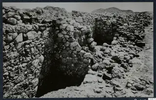 Rubble stone walls and a dark recess during excavation at Soli, the theatre