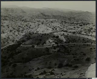 Rolling scrubland hills with a winding road, viewed from a height near Vouni