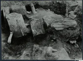 Finds in situ during excavation at Vouni Palace, with large stone blocks and clay fragments lying in a trench.