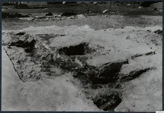Breakthrough in the stone floor of Room I in the Temple of Athena at Vouni, with a dark hole cut through a large slab.