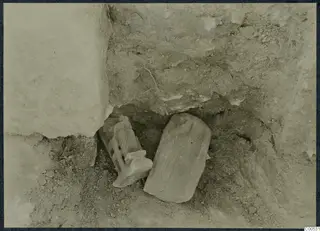 Two finds lying in excavated soil beside a large stone block at Vouni Palace