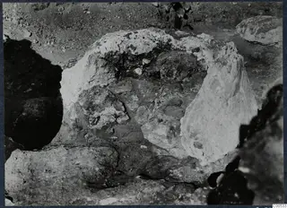 Excavation at Vouni palace with large pale stones lying in the soil.